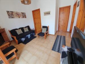 a living room with a couch and a tv at Casa vacanze Donna VALERIA in San Foca
