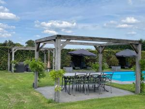 a patio with a table and chairs and a pool at B&B Il Settimo Cielo in Someren