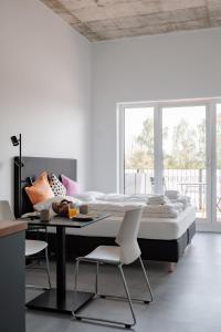 a bedroom with a bed and a table and chairs at Skyrise Apartments - Stilvoll wohnen, entspannt genießen in Bad Wörishofen