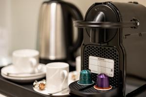 a coffee maker sitting on a counter with cups at Suites 1955 in Cagliari