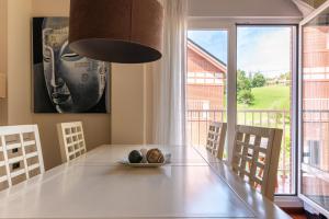 a dining room with a table and a large window at La Casa del Valle de Arce in Puente Arce
