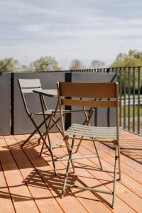 a wooden chair and a table on a deck at Skyrise Apartments - Stilvoll wohnen, entspannt genießen in Bad Wörishofen