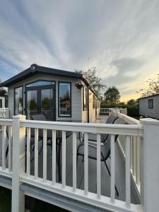 ein kleines Haus mit einem weißen Geländer auf einer Terrasse in der Unterkunft Burano Nook - Tattershall Lakes in Tattershall
