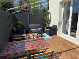 taras ze stołem i krzesłami z drewna w obiekcie Logement avec terrasse,4 pers, parking w mieście Concarneau