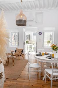 a white dining room with a table and chairs at Matogianni Rooftop Getaway in Mykonos Town I Beyond Blue Villas in Mýkonos City