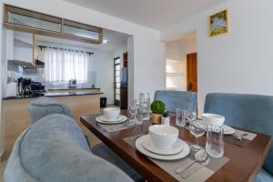 Un comedor con mesa y sillas de madera. en Modern 3BR in Tatu City With Pool, en Nairobi