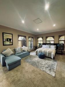 a large bedroom with a bed and a couch at Villa Bloemé Guesthouse in Bloemfontein