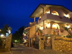 a large house with a stone wall at night at Hotel Louis II in Ciampino