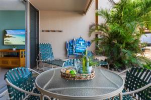 un patio con tavolo e sedie e uno zaino blu di Nohonani 101 a Kahana