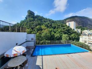 a swimming pool on top of a building with a mountain at Royalty Copacabana Hotel in Rio de Janeiro