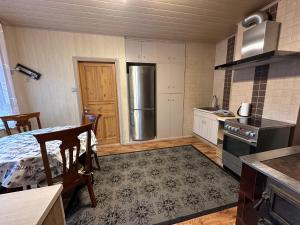 a small kitchen with a table and a refrigerator at Kastan House in Mustvee +4 photos