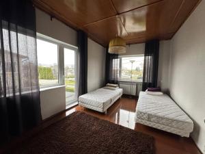 a living room with two beds and two windows at Kastan House in Mustvee