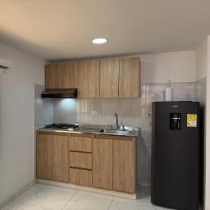 a kitchen with a black refrigerator and a sink at Air-conditioned apartment 201 in Floridablanca