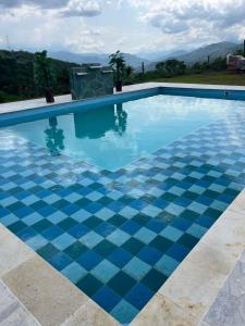 a swimming pool with a checkered tile floor at Divino Glamping Romantico Jacuzzi Villeta NUEVO in Villeta