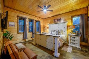 um quarto com uma cama e um ventilador de teto em Lazy Daze Lodge - Hot Tub Playset & Firepit em Broken Bow