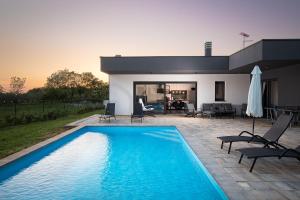 a large blue swimming pool in front of a house at Vila Nora with heated pool in Marčana +44 photos