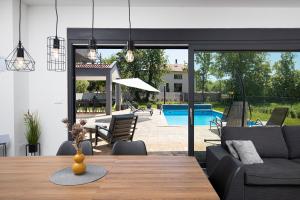 a dining room with a table and a pool at Vila Nora with heated pool in Marčana