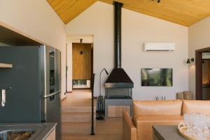 a living room with a couch and a stove at Elegante bangalô de campo 5 - Taquaras Huts in Rancho Queimado