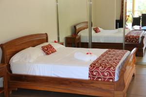 a bedroom with two beds and a mirror at Summer Self Catering in Baie Sainte Anne