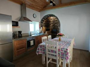 eine Küche mit einem Tisch mit Stühlen und einem Waschbecken in der Unterkunft Casa da Marta - Azorean Nature Escape in Nordeste + 62 Fotos