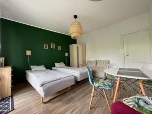 two beds in a room with a green wall at Pokoje Ostróda Centrum in Ostróda