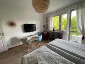 a bedroom with two beds and a table and a tv at Pokoje Ostróda Centrum in Ostróda