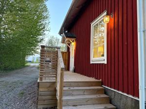 KumlaSveabo的通往一栋带窗户的红房子的木楼梯
