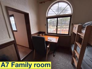 a room with a desk and a bed and a window at 海峡別荘 in Shimonoseki