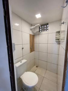 a small bathroom with a toilet and a shower at Jardim encantado hospedagens in Pipa