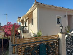 a house with a wooden fence and a gate at Octopus Garden, Koralli Studio in Travliáta