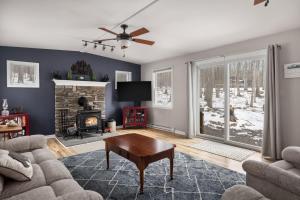 a living room with a couch and a fireplace at Dog-Friendly w Hot Tub, Fire Pit & River Access in Great Cacapon +40 photos