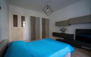 a bedroom with a blue bed and a tv at La casa di Emma in Trieste +8 photos