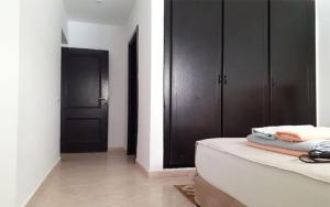 a bathroom with black cabinets and a bath tub at Appartement Dans Résidence jawhara in Essaouira