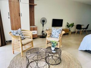 sala de estar con sillas de mimbre y TV en Camarque - Umdloti's Ocean Escape, en Umdloti