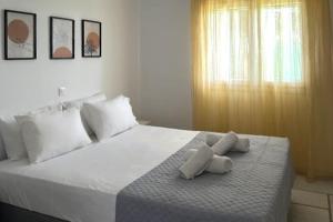 a bedroom with a large white bed with towels on it at Barewake 's place Charming Retreat - Calm escape Apt in Kamári