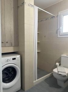 a bathroom with a washing machine and a toilet at Barewake 's place Charming Retreat - Calm escape Apt in Kamári +16 photos