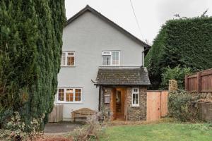 ein weißes Haus mit einem großen Baum in der Unterkunft A Charming Cottage, Christow Dartmoor National Park in Christow