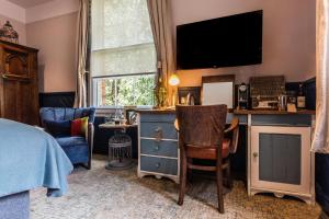 a bedroom with a bed and a tv on a wall at Hand and Spear in Weybridge