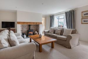 ein Wohnzimmer mit zwei Sofas und einem Kamin in der Unterkunft A Charming Cottage, Christow Dartmoor National Park in Christow