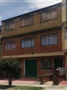 een rood bakstenen gebouw met een groene garage bij Plaza de Bolivar in Bogota