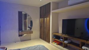 Μια τηλεόραση ή/και κέντρο ψυχαγωγίας στο Chic apartment in Aldea Mayab with Lagoon access and private splash pool