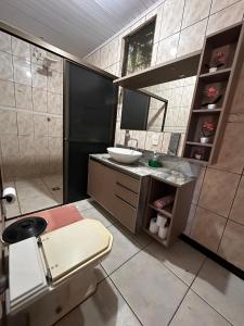 a bathroom with a toilet and a sink at Casa grande com piscina in Foz do Iguaçu