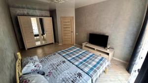 a bedroom with a bed and a flat screen tv at Яровиця 6 поверх in Luts'k