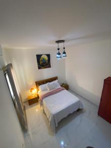 a bedroom with a bed in a white room at Appartement Chic d'une Chambre avec Balcon à Médina, Dakar in Dakar +3 photos