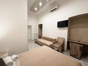 a room with two beds and a couch and a tv at Benvenuto a Napoli in Naples +77 photos