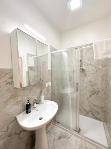 a white bathroom with a sink and a shower at Benvenuto a Napoli in Naples