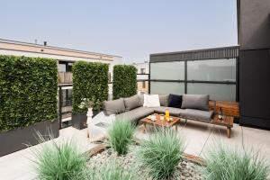 ワルシャワにあるJacuzzi Hideout - Warsaw private terrace - Free Parkingの建物の上にソファ付きのパティオ
