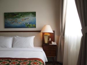 Postel nebo postele na pokoji v ubytování Kapitan Kongsi Boutique Hotel