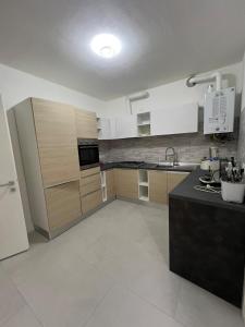 Una cocina con gabinetes blancos y una encimera negra. en Central Charme - Conegliano, en Conegliano