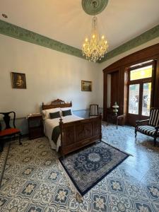 a bedroom with a bed and a chandelier at Hotel Boutique Del Buendia in San Luis Potosí